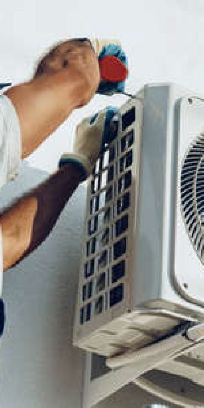152077791-repairman-in-uniform-installing-the-outside-unit-of-air-conditioner